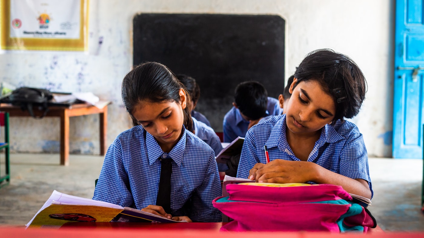 Two children reading and writing at a desk